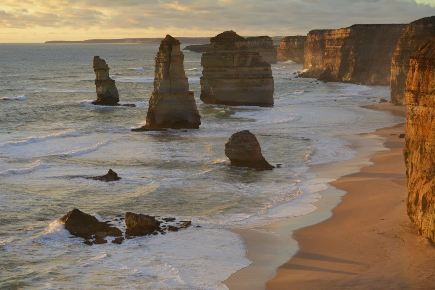 The limestone stacks of the Twelve Apostles in the Southern Ocean surf, along the Great Ocean Road cliffs in golden light