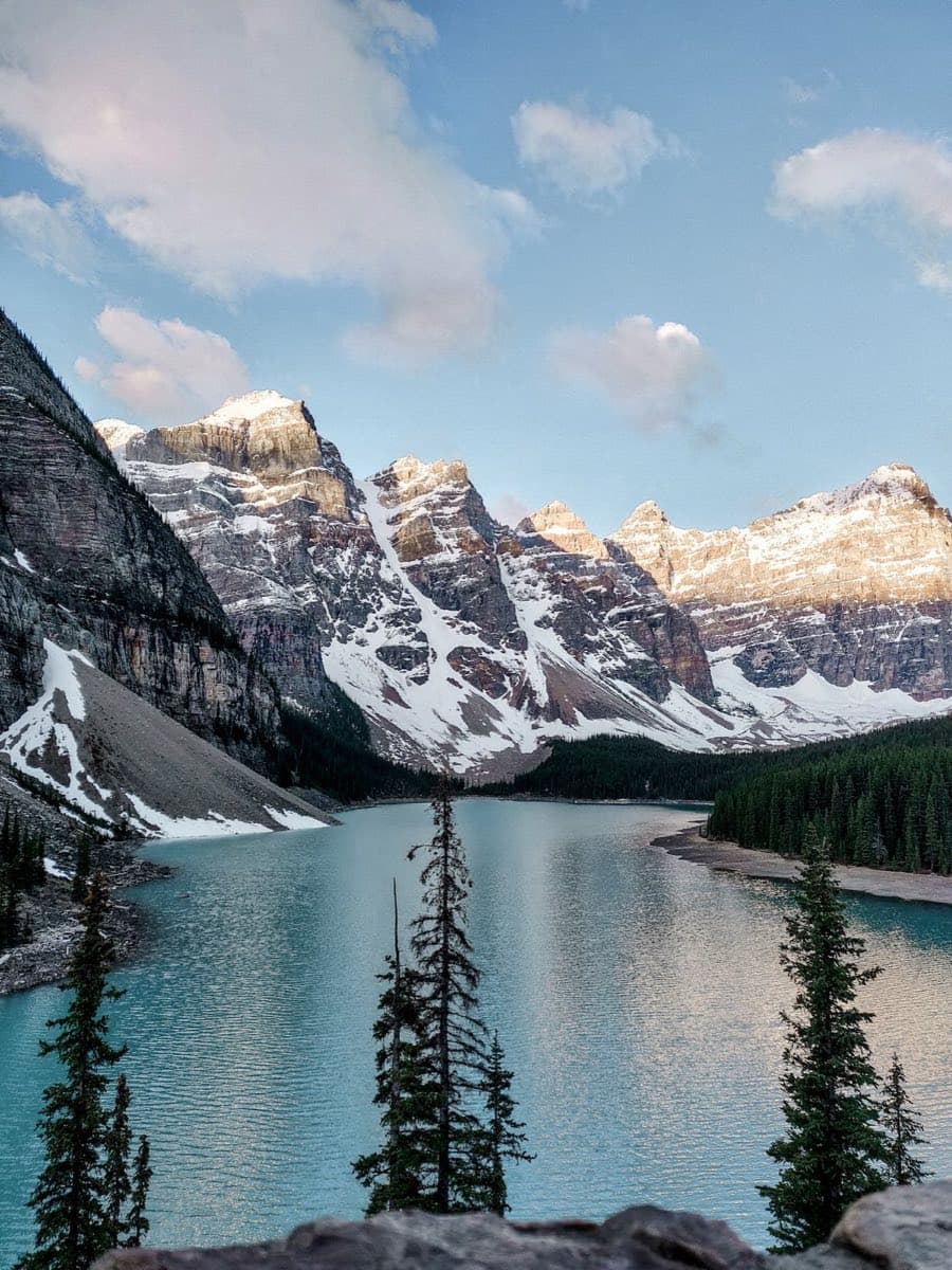 Turquoise Moraine Lake in the Valley of the Ten Peaks at sunrise, snow-capped summits gilded by first light
