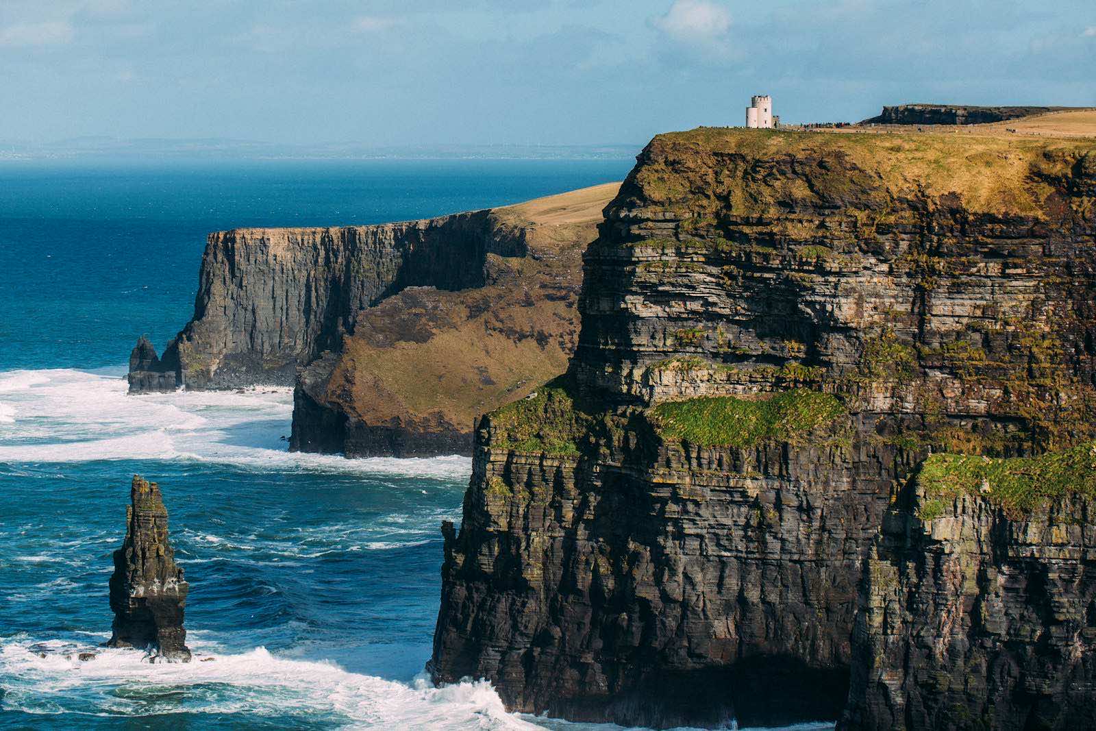 The Cliffs of Moher with O'Brien's Tower on the clifftop and the Branaunmore sea stack battered by the Atlantic