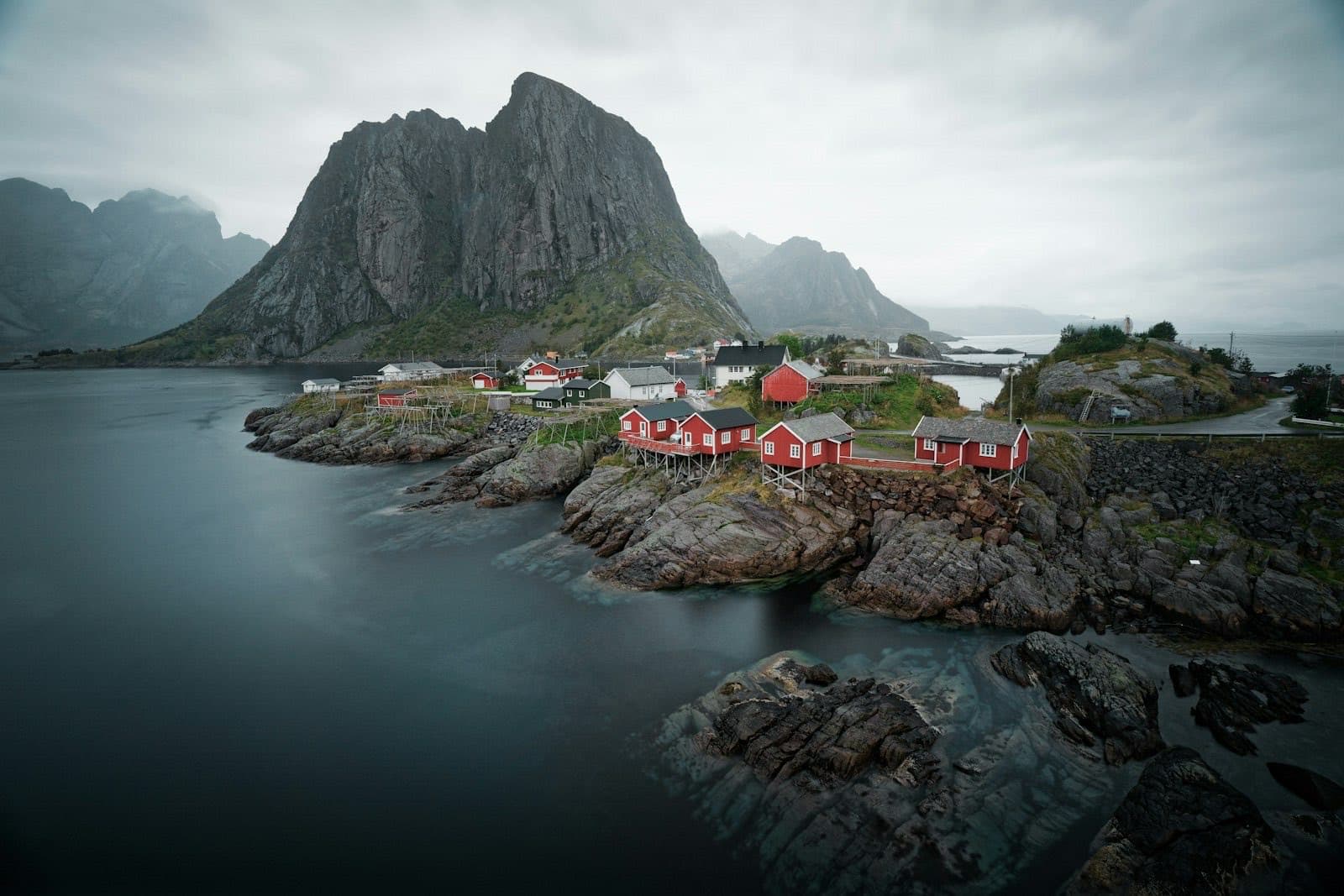 The red fishermen's cabins of Hamnøy on their rocks, beneath the Festhelltinden cliffs in the Lofoten Islands
