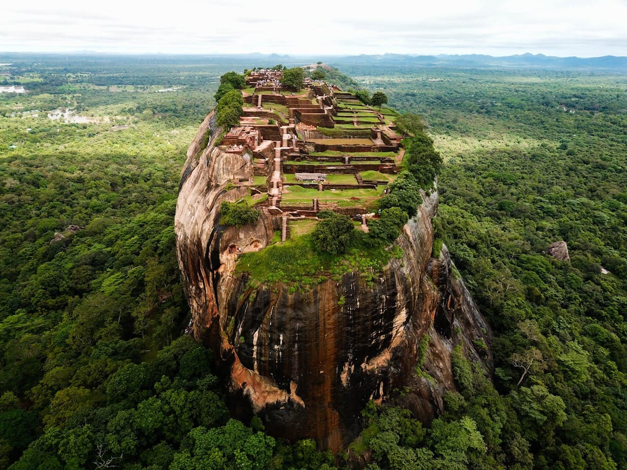 Vue aérienne du rocher de Sigiriya, ses ruines du palais royal en terrasses au sommet, entouré d'une forêt tropicale verdoyante