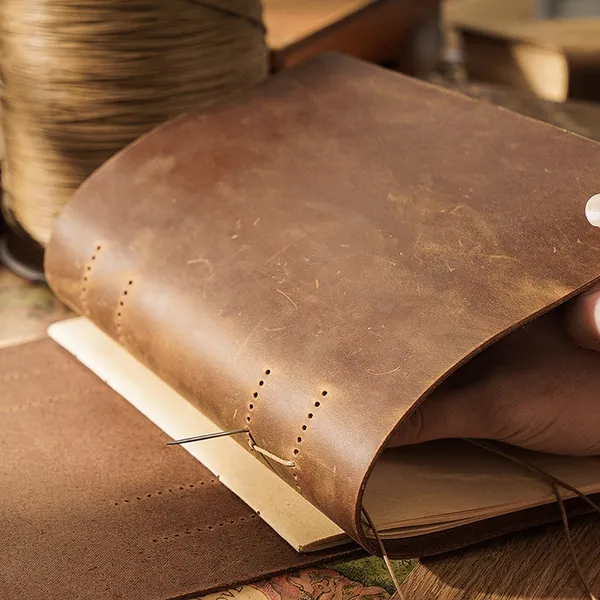 Leather journal open on kraft pages